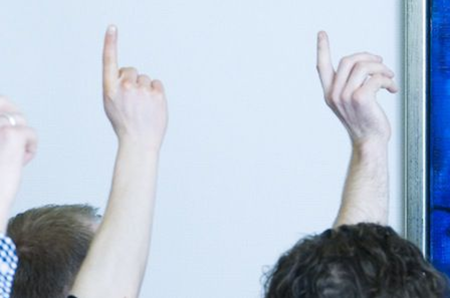 En gruppe mennesker rækker hånden i vejret